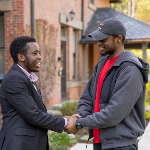 Laidlaw scholars smile and shake hands.